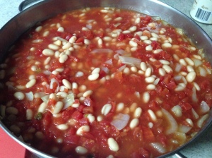 Ounions, garlic, beans, broth and tomatoes simmering